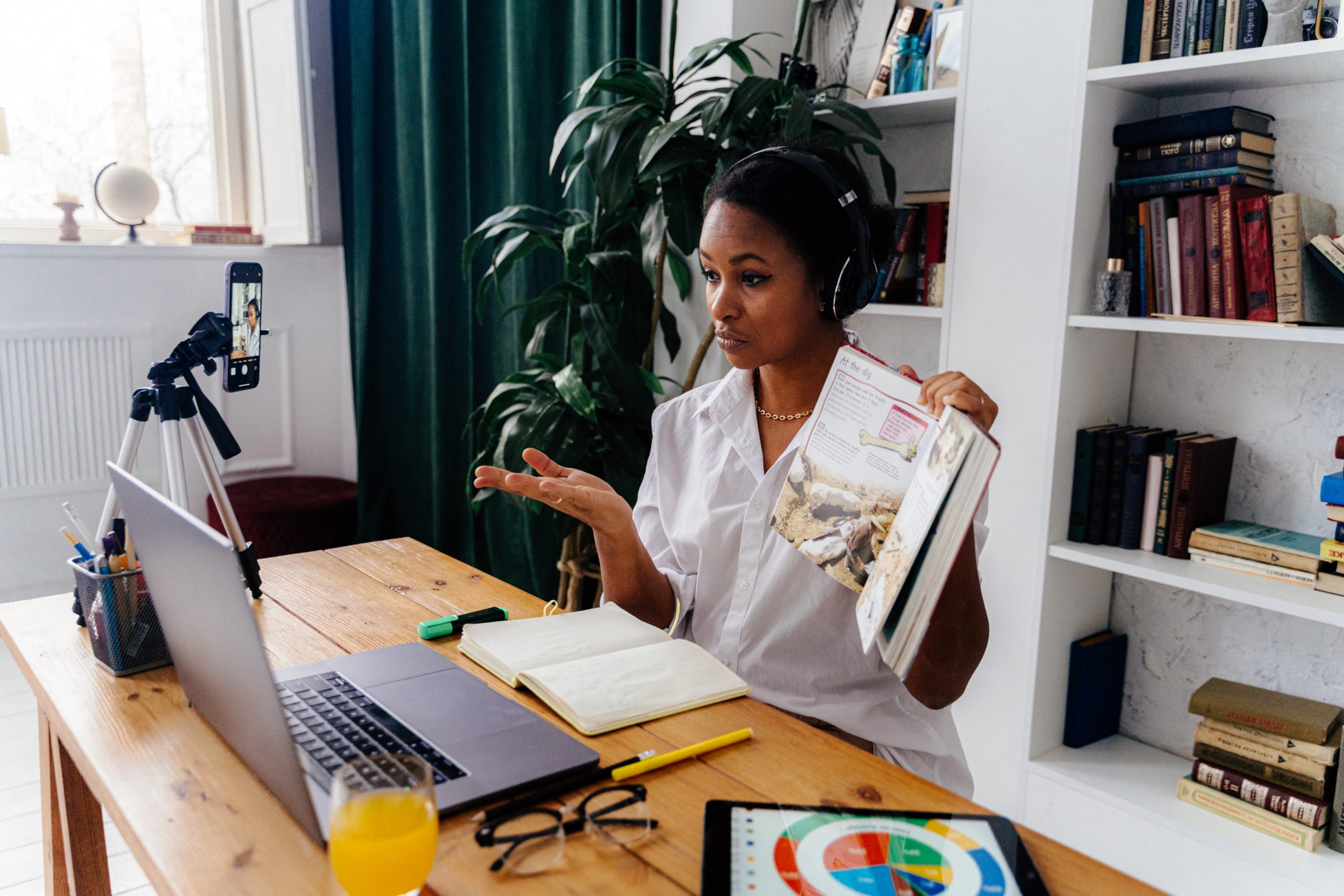 Online Course context, woman teaching in front of laptop and camera with open book