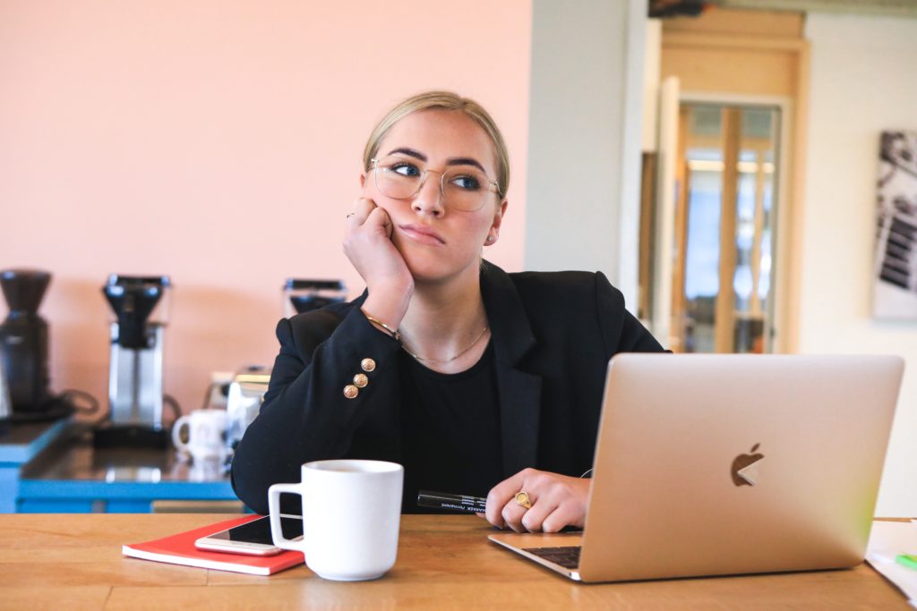 Procrastination context, woman at desk with laptop